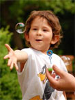zdjęcie: chłopczyk robiący bańki mydlane; fot. sxc.hu