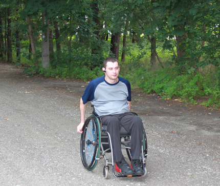 Na zdjęciu: Jacek Czech na wózku jedzie po ulicy