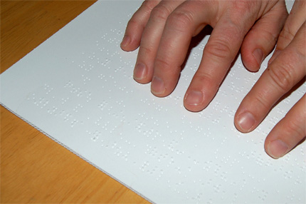 Na zdjęciu: czytanie dokumentu w alfabecie Braille'a