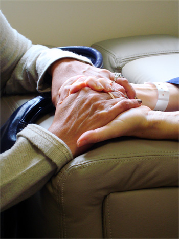 Na zdjęciu: opieka nad osobą chorą - trzymanie się za ręce